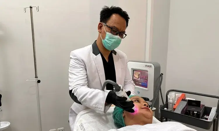 Andy Prasetia, dokter dan Founder Perfecta Aesthetic Clinic sedang melakukan treatment kepada konsumen.