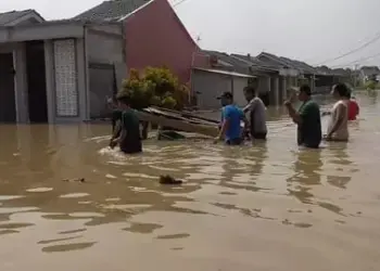 GENANGAN AIR: Situasi di Perumahan Grand Harmoni II, Desa Bunar, Kecamatan Sukamulya, Selasa (30/4). Terlihat warga yang sedang berjalan ditengah genangan air. (ALFIAN HERIANTO)