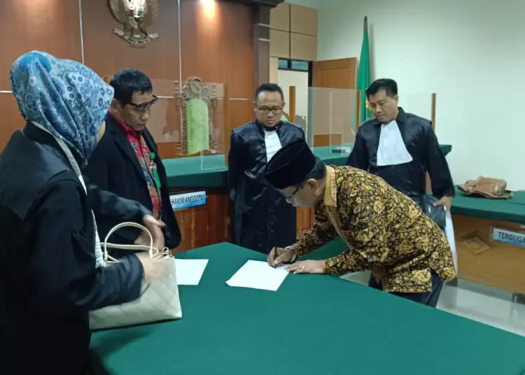 Kades Nagara, menandatangani berita acara vonis bebas di Pengadilan Negeri Serang. (ISTIMEWA)