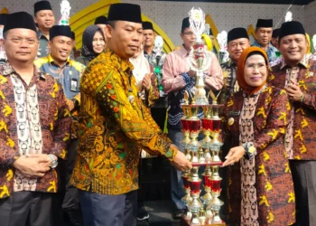 Bupati Serang Ratu Tatu Chasanah, menyerahkan piala juara umum MTQ terhadap Camat Anyer. (ISTIMEWA)