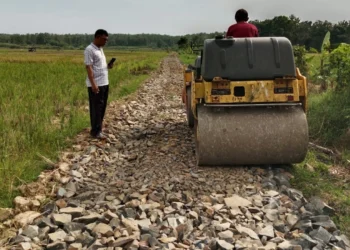 Kades Cikeusik, Bayi Rukmana (kiri), meninjau pembangunan jalan Ciranta, Senin (3/6/2024). (ADIB FAHRIE/SATELITNEWS.COM)