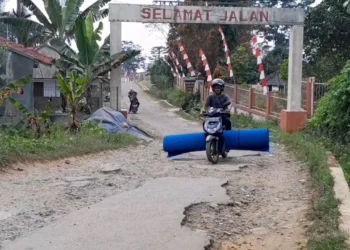 Seorang pengendara sepeda motor, melintas di ruas jalan Cicadas - Pasirpeuteuy - Kaduengang, yang kondisinya rusak berat, Selasa (11/6/2024). (ADIB FAHRIE/SATELITNEWS.COM)