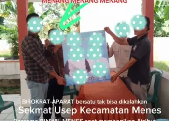 Dua orang yang diduga ASN di lingkungan Pemkab Pandeglang, memegang poster Pasangan Balon Bupati dan Wakil Bupati Pandeglang. (ISTIMEWA)