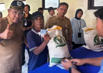 Kepala DPKP Pandeglang, M. Nasir (kanan), melakukan monitoring pendistribusian bantuan beras dari Bapanas. (ISTIMEWA)