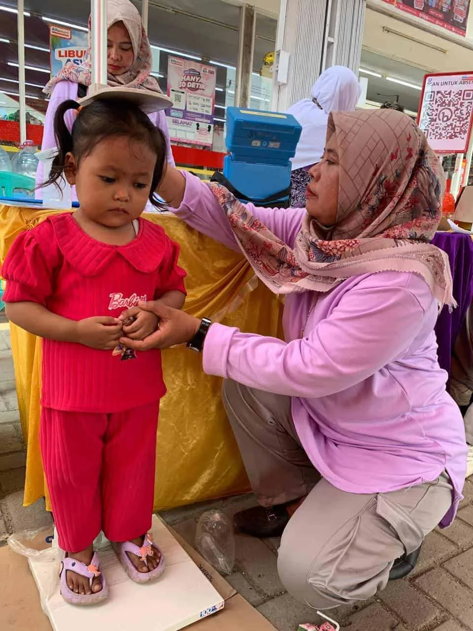 Alfamart dan Sweety Dry X-Pert, Buka Layanan Posyandu Untuk Anak dan Balita, di halaman gerai Alfamart di Kecamatan Petir, Kabupaten Serang, Jumat (12/7/2024). (SIDIK/SATELITNEWS.COM)