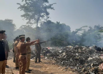 Camat Tigaraksa, Cucu Abdurosyied memantau TPS liar yang terbakar. (ALFIAN/SATELIT NEWS)