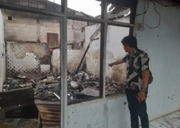 Petugas memperlihatkan ruko yang terbakar. (ISTIMEWA)