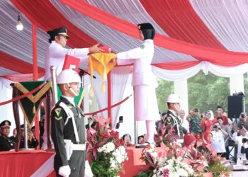 Pj Gubernur Banten Al Muktabar, serahkan bendera pusaka Merah Putih, kepada petugas Paskibra, Sabtu (17/8/2024). (LUTHFI/SATELITNEWS.COM)