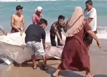 Warga mengevakuasi temuan mayat tanpa identitas, di pesisir pantai Rancecet. (ISTIMEWA)