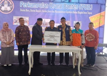 Pj Gubernur Banten Al Muktabar, menyaksikan penyerahan simbolis bantuan program kampung bebas rentenir, dari pendiri Yayasan Dompet Dhuafa Parni Hadi (kanan), kepada Ketua Umum PUB Taufiqurahman Ruqi (kiri). (LUTHFI/SATELITNEWS.COM)