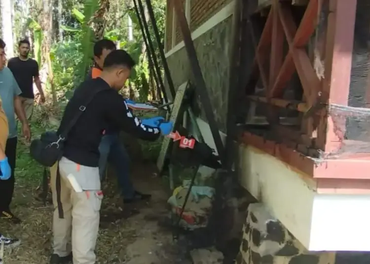 Petugas Inafis Polres Pandeglang, memeriksa bangunan rumah dinas yang diduga dibakar OTK. (ISTIMEWA)