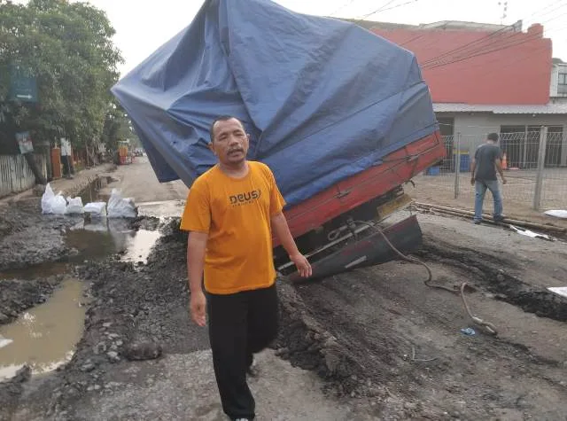 Truk Bermuatan Keramik Terperosok di Jalan KS Tubun, Imbas Kebocoran Pipa Air PDAM