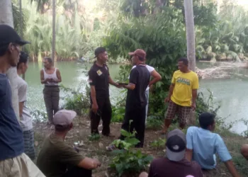 Warga Desa Tangkilsari, Kecamatan Cimanggu, Kabupaten Pandeglang, berkumpul di pinggir Sungai Cijaralang, sambil melakukan pencarian korban diterkam buaya, Jumat (18/10/2024). (ISTIMEWA)