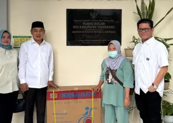 BERI BANTUAN: Calon Bupati Tangerang nomor urut 1 Mad Romli ditemani istri saat memberikan bantuan kursi roda kepada Alika yang diterima langsung oleh Robiah, nenek Alika, Selasa (12/11). (ISTIMEWA)