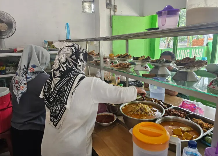 WARTEG: Situasi di salah satu rumah makan warteg di Tigaraksa Minggu (1/12). Terluhat, Nur Aulia sedang menyiapkan pesanan para pelanggan. (ALFIAN/SATELIT NEWS)