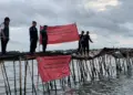 Petugas membentangkan spanduk, di pagar Laut di Kabupaten Tangerang, beberapa waktu lalu. (DOKUMEN/SATELITNEWS.COM)